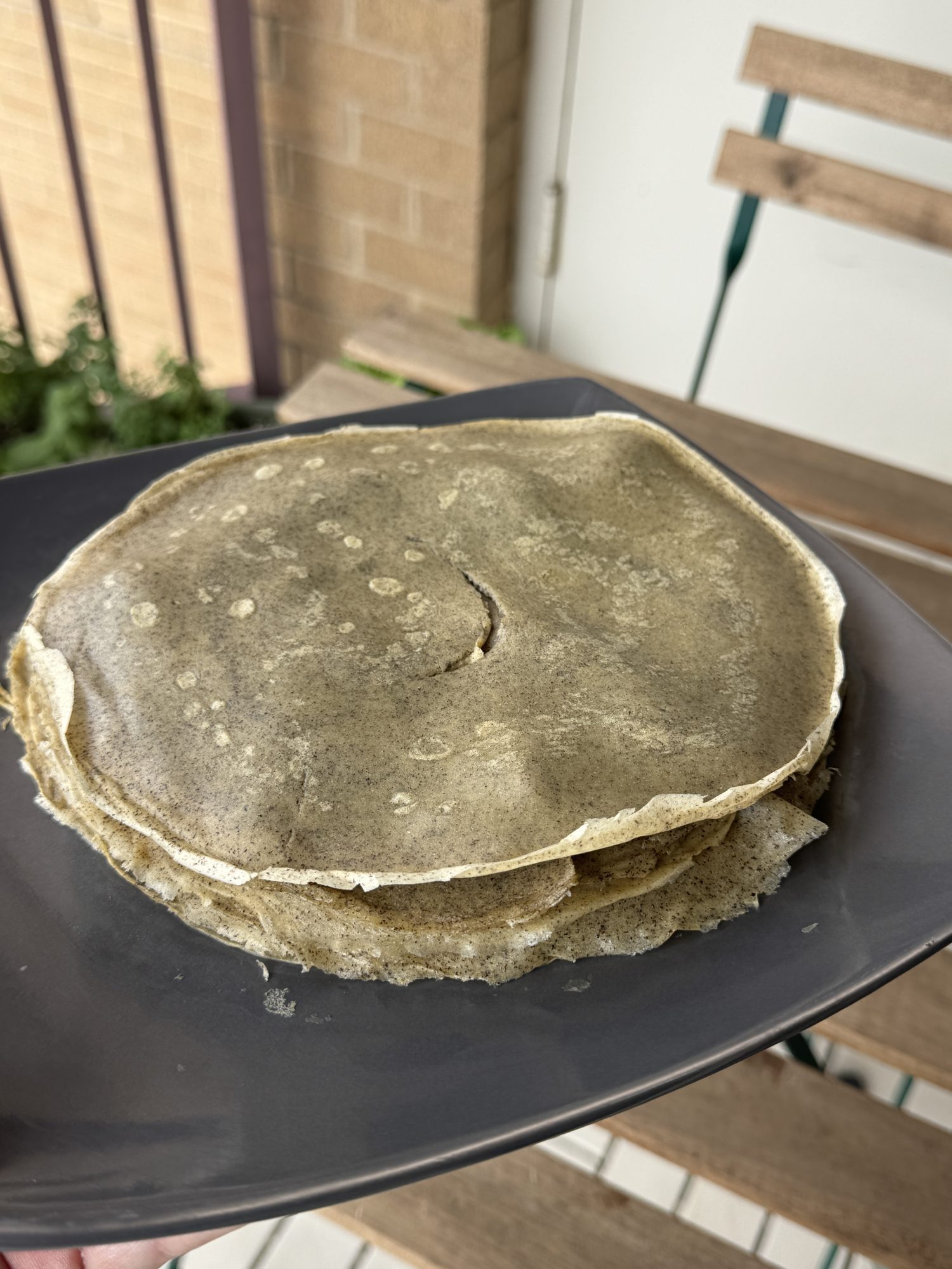 A stack of buckwheat crepes on a plate.