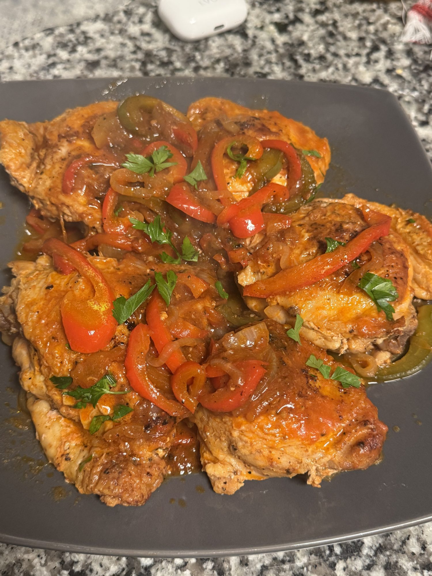 Poulet Basquaise topped with vibrant red peppers and fresh parsley.