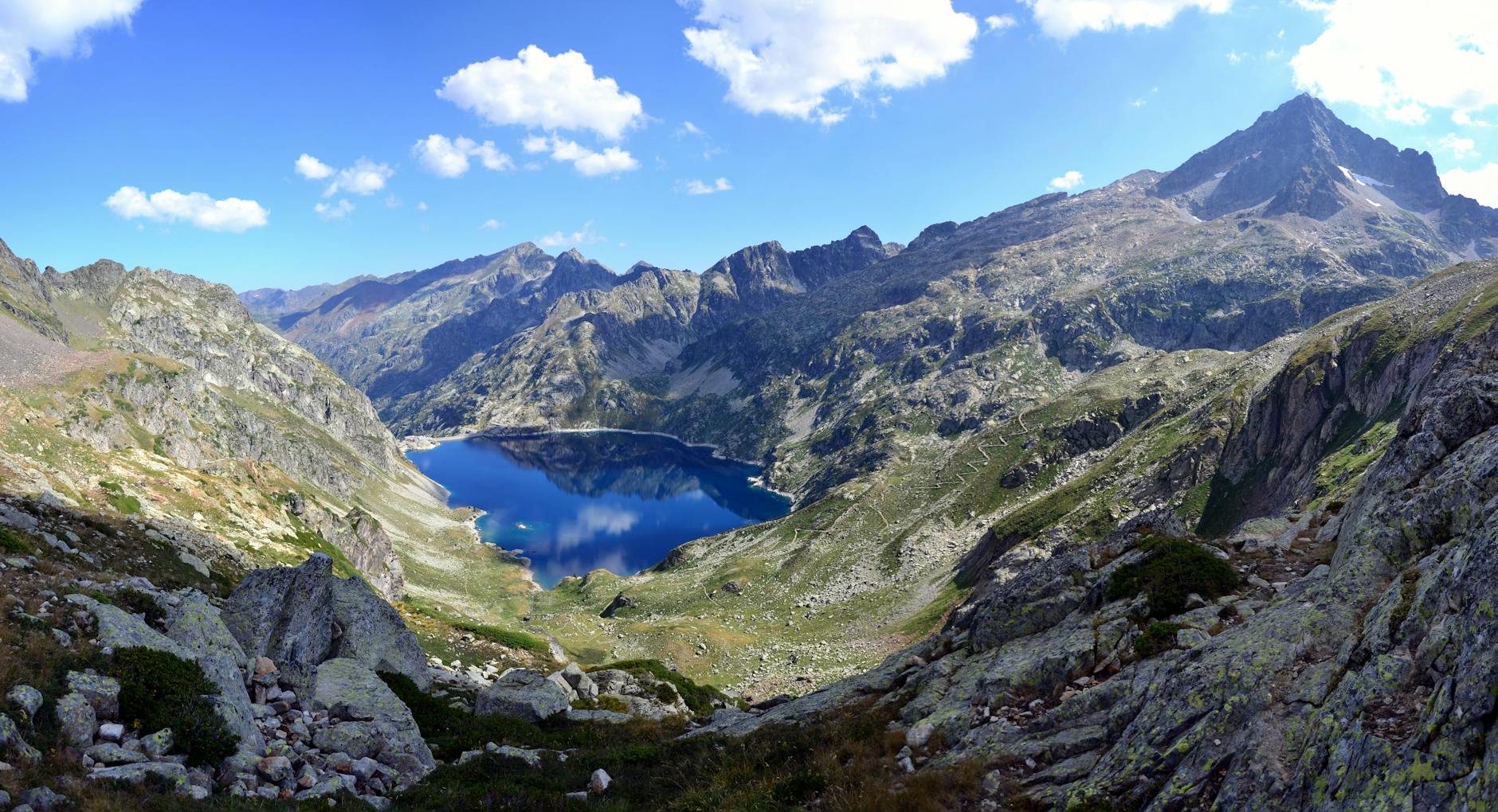 lake surrounded by mountain top under blue sky at daytime