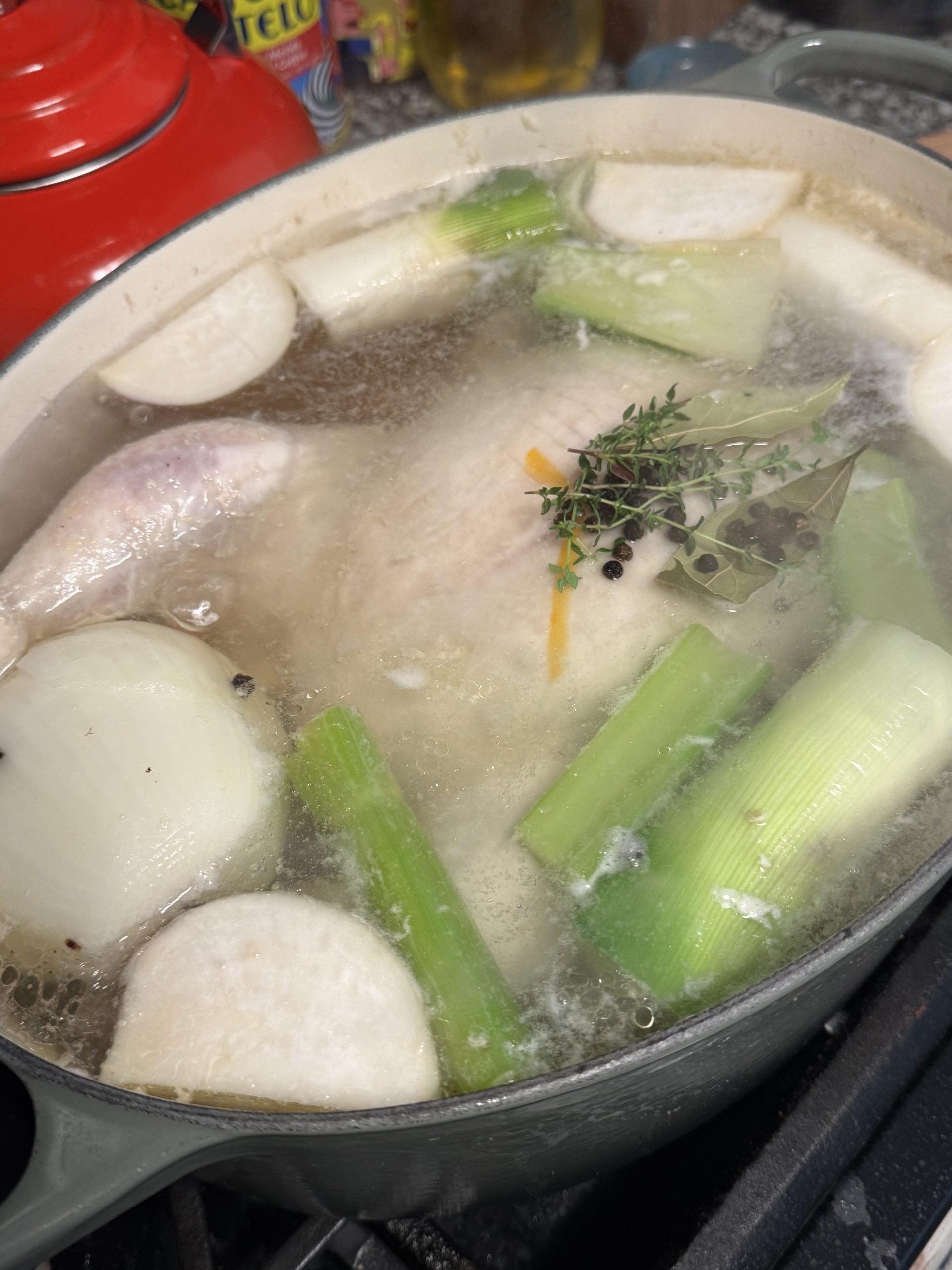 Chicken cooking in a pot with veggies