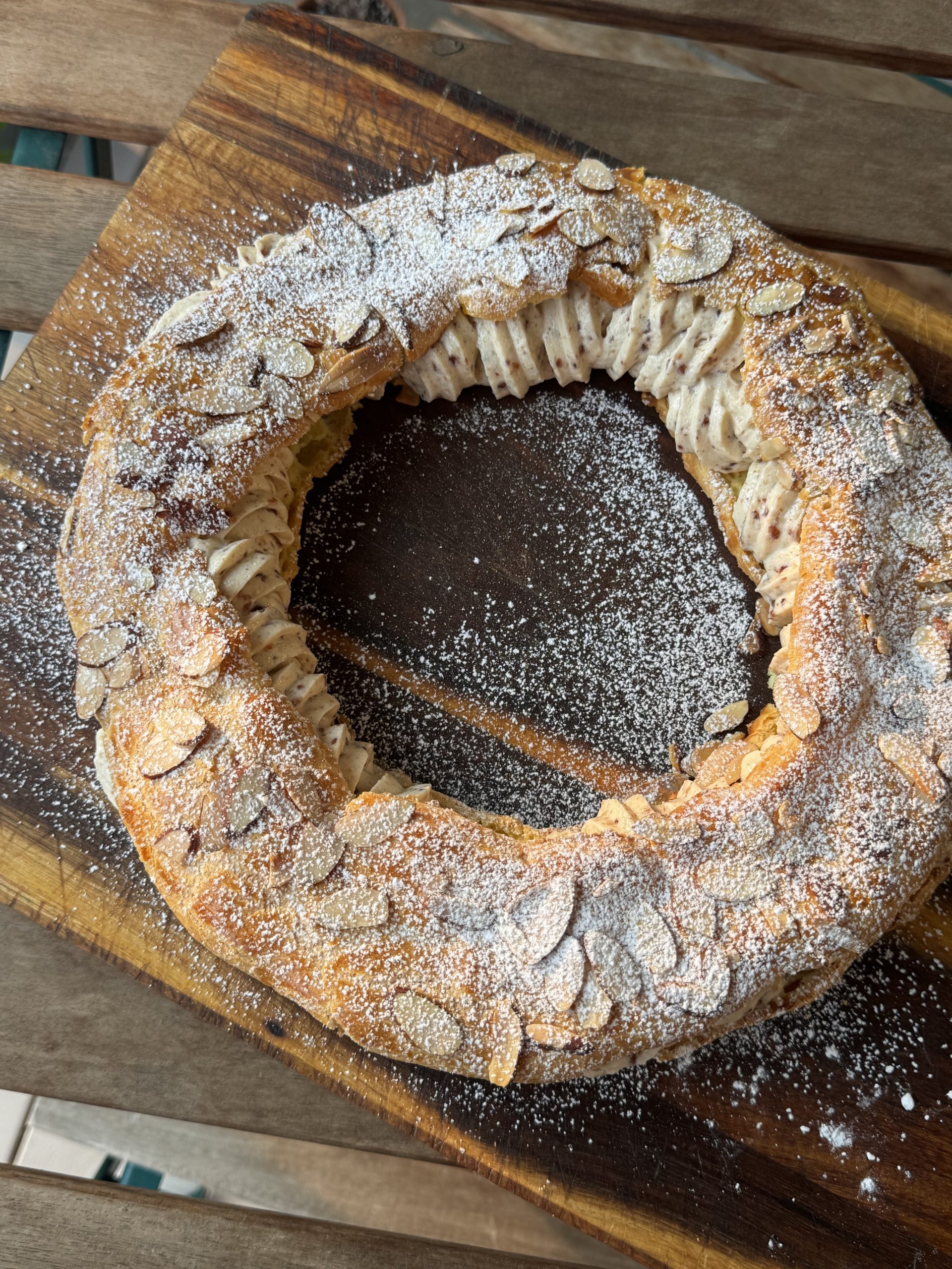Overhead Profile: Paris-Brest, Choux pastry ring filled with hazelnut mousseline and topped with toasted almonds and powdered sugar