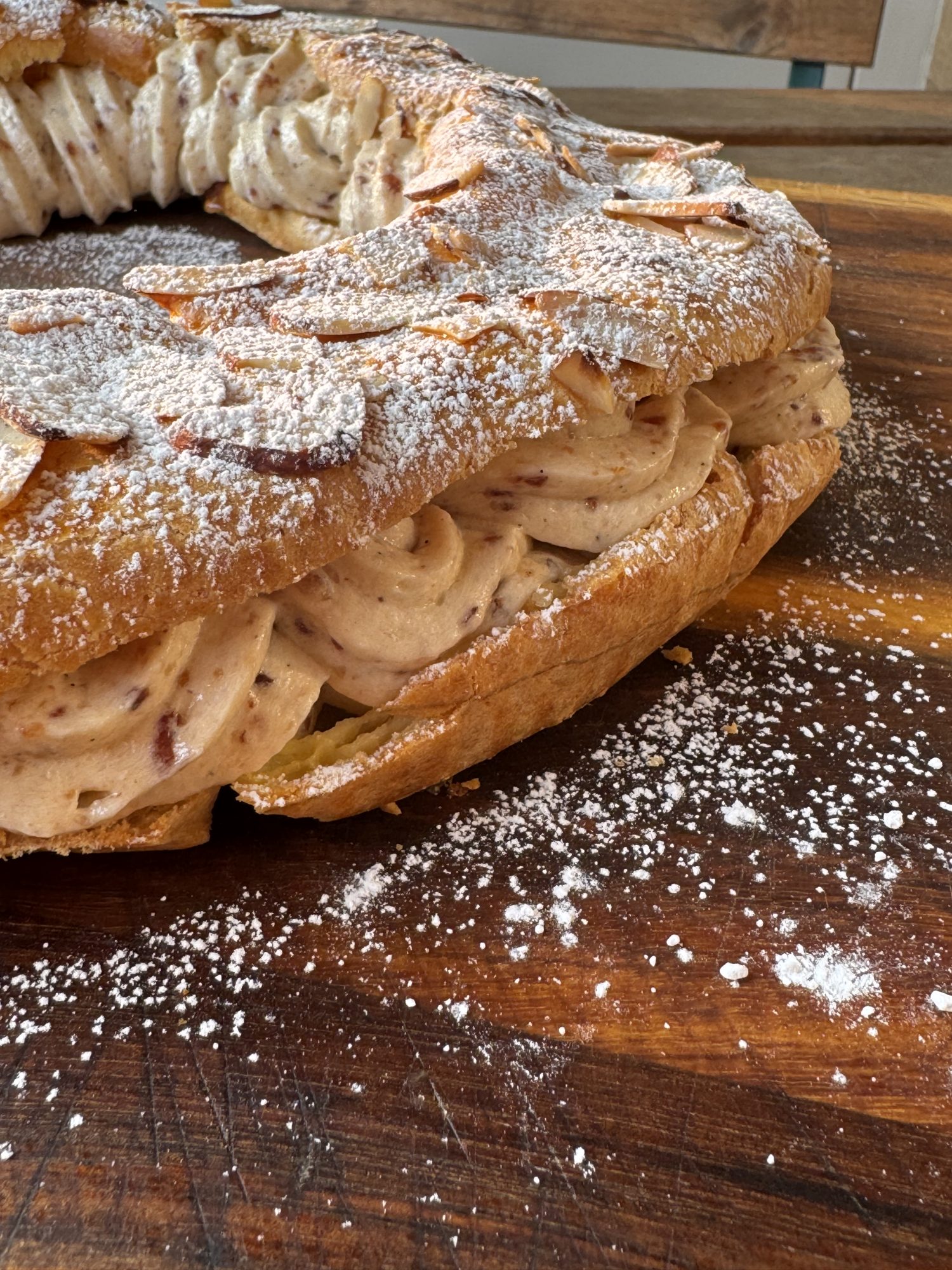 Side Profile: Paris-Brest, Choux pastry ring filled with hazelnut mousseline and topped with toasted almonds and powdered sugar